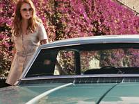 Кадр Дама в очках и с ружьем в автомобиле